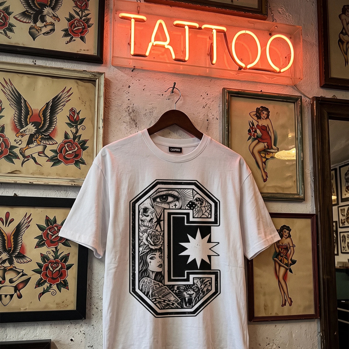 Tattoo Monogram camiseta blanca colgada en estudio de tatuajes