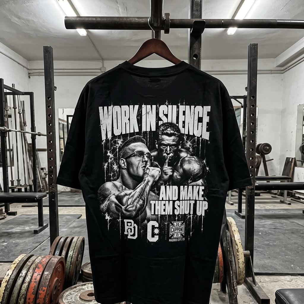 Work In Silence camiseta negra colgada en un rack de sentadillas